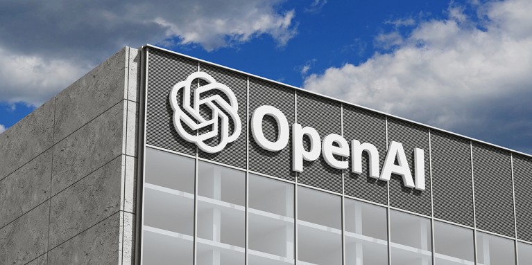 A modern grey office building facade with OpenAI signage on the front.