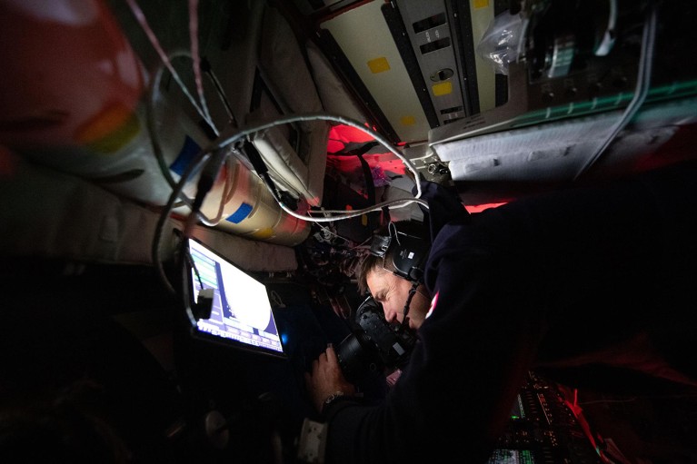 Artemis II Mission Specialist Jeremy Hansen captires images through the Orion spacecraft window during the lunar flyby.