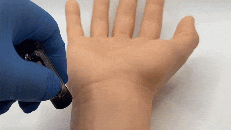 Sequence showing a prosthetic hand with the words Hello World appearing being activated by a handheld light source and then being erased with another light source.