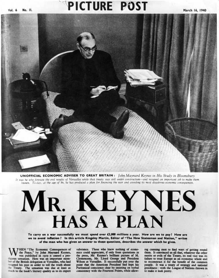 A magazine cutting from Picture Post in 1940 showing a black and white image of John Maynard Keynes saeated on a small bed with a notebook in hand.