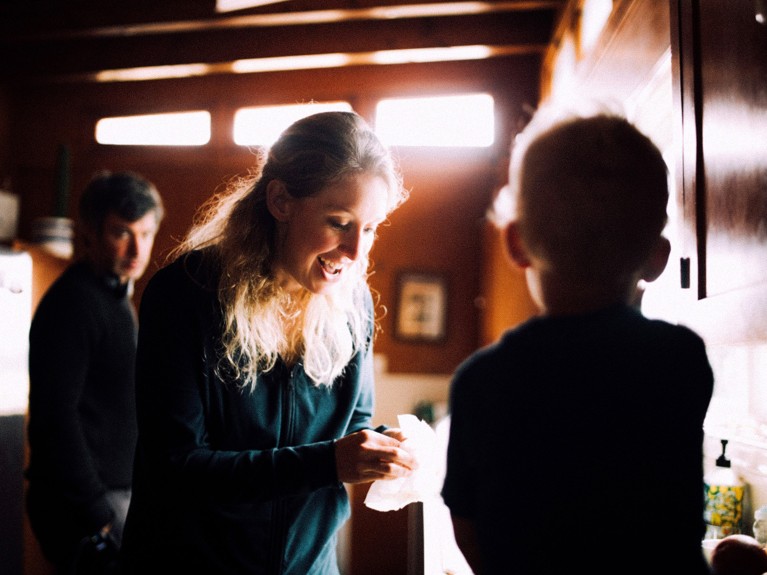 Movie still with director Nathan Fielder and Elizabeth Holmes, and a child with its back in the frame, from “You Can See Everything”, 2026.