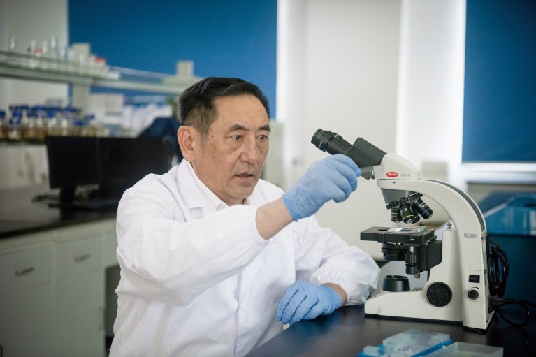 Chen Huanchun in front of a microscope.