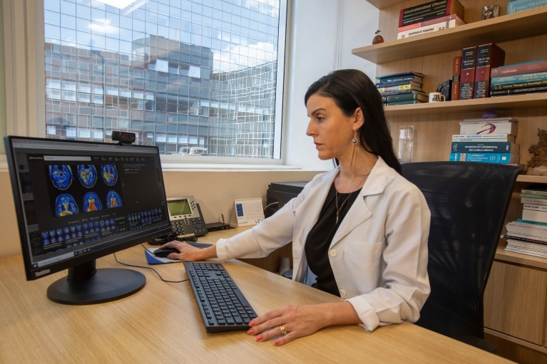 A female doctor works at a computer in an office