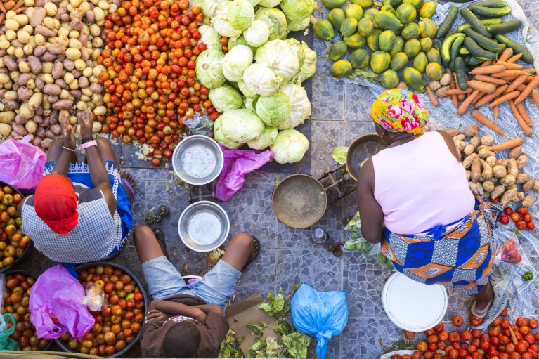 Vendeurs vendant une sélection de légumes frais sur un marché de rue.