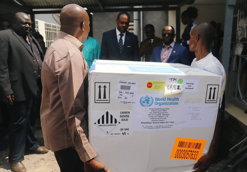 Congolese Health Ministry officials carry the first batch of experimental Ebola vaccines.