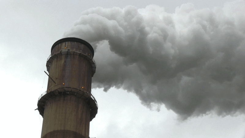 Looping video of smoke billowing out the top of a stack at a power plant