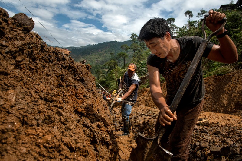 Mężczyźni szukają ocalałych po osunięciu się ziemi na Filipinach