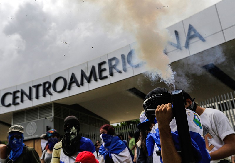 A student fires a hime made mortair during a student protest outside UCA in Nicaragua