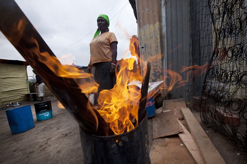 Women burns wood for fuel in Soweto Johannesburg