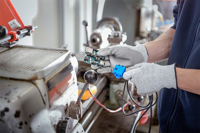 An engineer fitting sensors in a robotics facility, closeup photograph