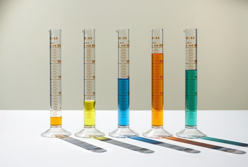 Bar chart made of measuring cylinders filled with different amounts of varied coloured liquids