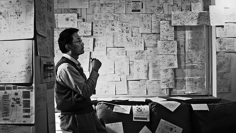 A scholar studying information posted on the walls of an office