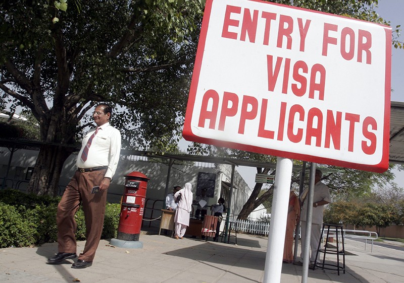 A signboard indicates the start of the queue for visa applicants at the U.S. Embassy in New Delhi
