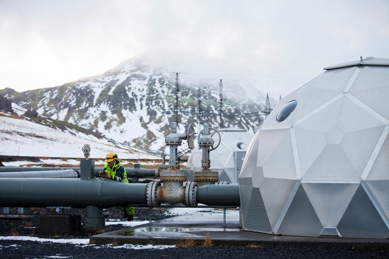 A man works on a pipe beside a carbon injection site well near Reykjavik Energy's Hellisheidi Geothermal Power Plant