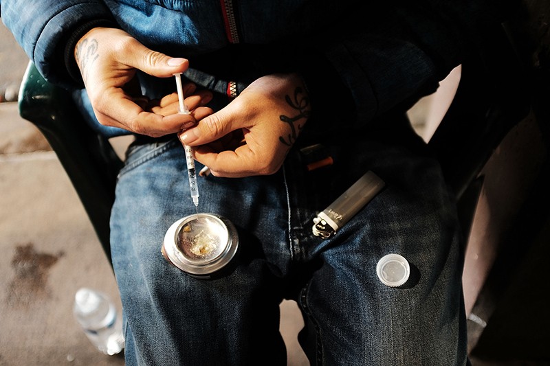A man in Philadelphia prepares heroin to inject