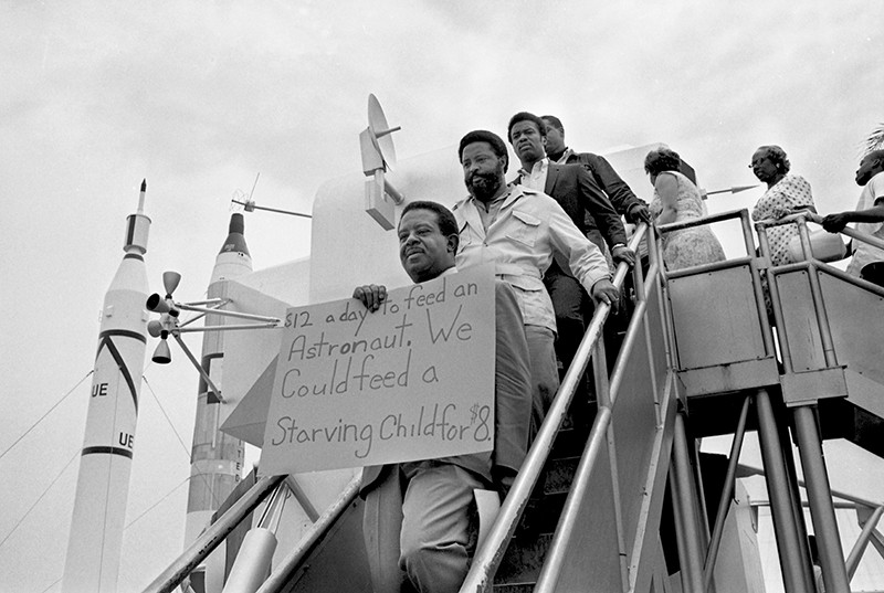 Protesters walk down steps at the Apollo 11 moon launch on 15 July 1969