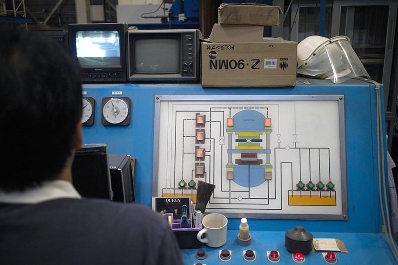 Takashi Taniguchi stands at the controls of his hydraulic press.