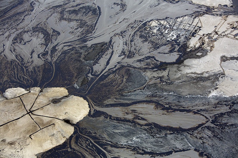 Oil goes into a tailings pond at the Suncor tar sands operations near Fort McMurray, Alberta, Canada