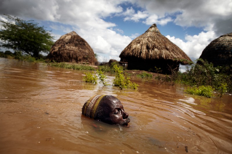 60 year Kenyan village chief struggles in flood water