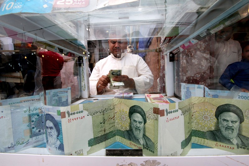 A man counts Iranian rials at a currency exchange shop