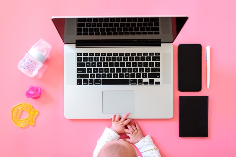 Top view flatlay of baby items and laptop with phone
