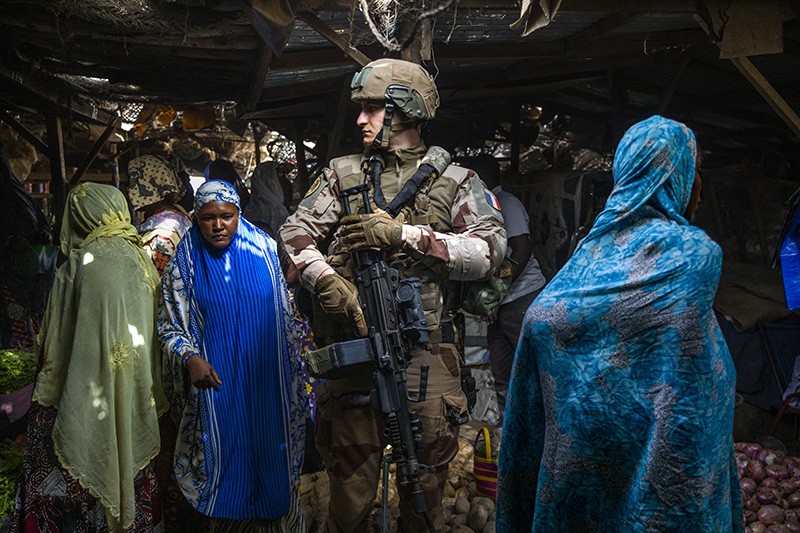 A French soldier from the Barkhane force walks among women shopping in a covered market in Gao, Mali