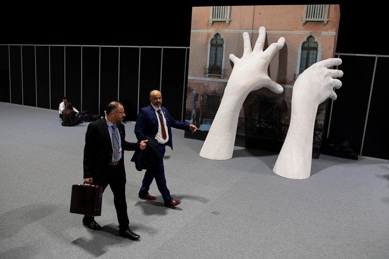 Participants walk past an sculpture during the opening day of the UNFCCC COP25 climate conference