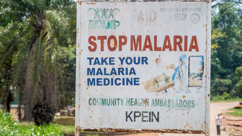 A sign reads Stop Malaria Ganta, Liberia.