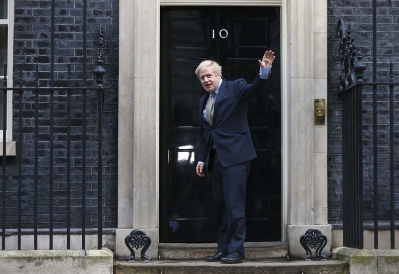 Boris Johnson, U.K. prime minister, waves to the media as he arrives at number 10 Downing Street, on Friday, Dec. 13, 2019.