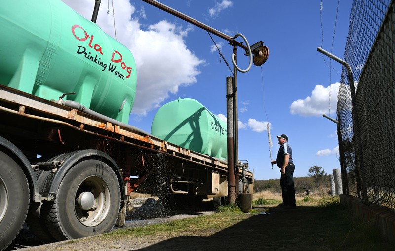 A man fills a tanker with potable water during a drought in Queensland, Australia