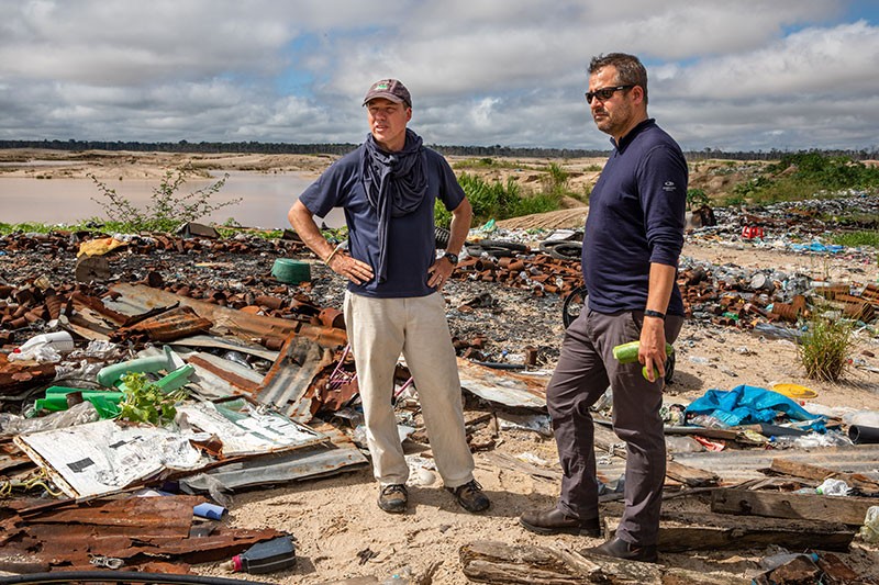 Miles Silman (L) and Luis Fernandez (R), from Wake Forest University, survey trash left at the illegal La Pampa gold miners