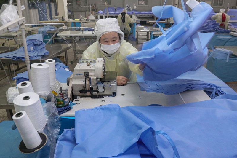 Un trabajador produce trajes protectores en una fábrica en Nantong, en la provincia oriental china de Jiangsu