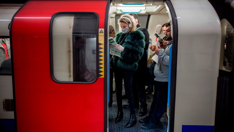 A commuter wears a mask as a precaution whilst travelling on a London Underground.