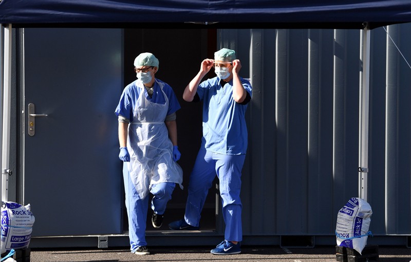Medical staff members wearing PPE of gloves, eye protection, face masks and aprons