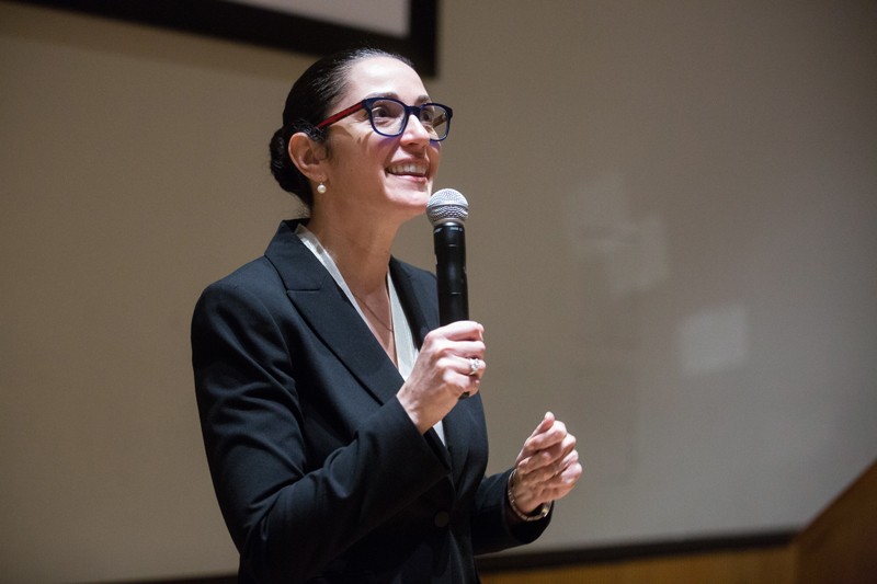 Ruth Gotian habla por un micrófono para una presentación en una conferencia