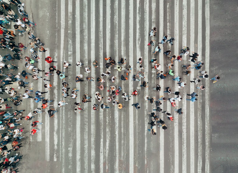 Overhead view of a crowd of people forming the shape of an arrow