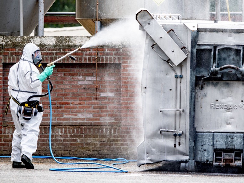 A man wearing a personal protective equipment suit (PPE) seen disinfecting the mink company.