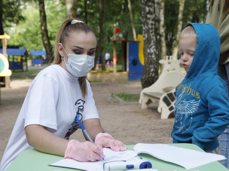 A member of staff receives a child in a day care centre at Moscow's secondary school No 1532.