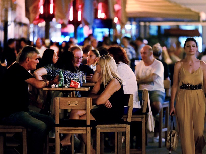 A crowd of people hanging out on the terraces of cafe bars while not wearing protective face masks, Croatia.