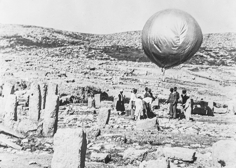 People standing at an archaeological site with balloon equipment.