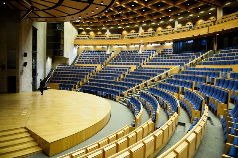 An large empty lecture theatre with a single figure crossing the stage.
