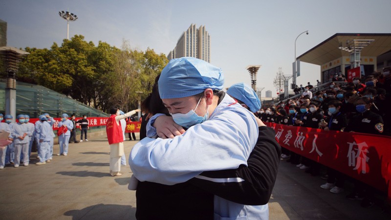 A medical worker embraces a member of a medical assistance team.