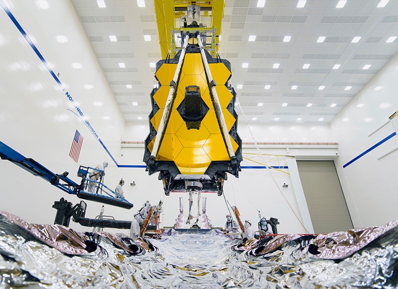 Integration teams carefully guide Webb’s suspended telescope section into place above its Spacecraft Element.