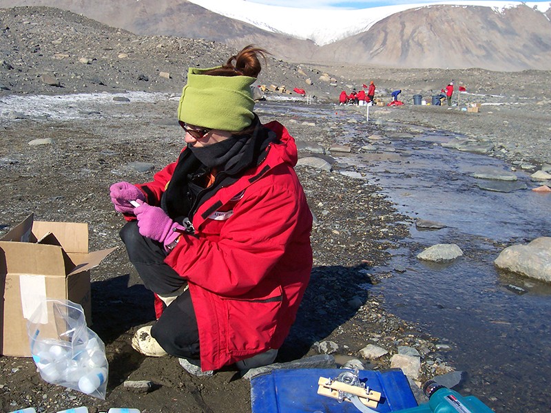 Researchers at the McMurdo Dry Valleys LTER collect stream samples.