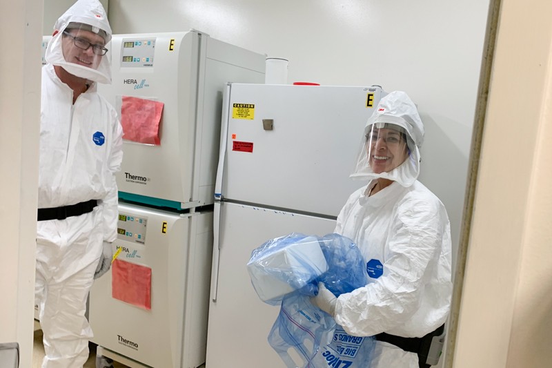 Timothy D Carroll and Lourdes Adamson in protective clothing accepting a patient sample