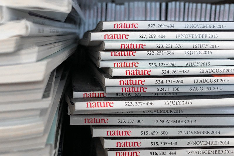 A pile of Nature journals on a shelf