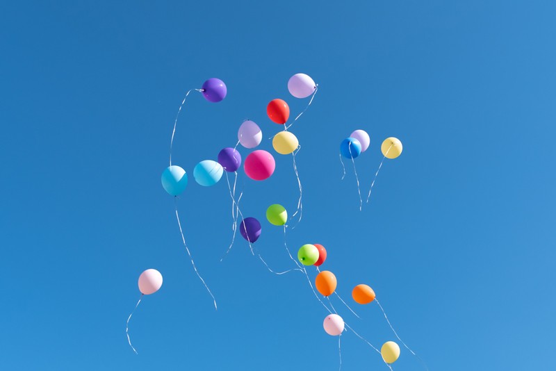 Coloured balloons in front of a blue sky