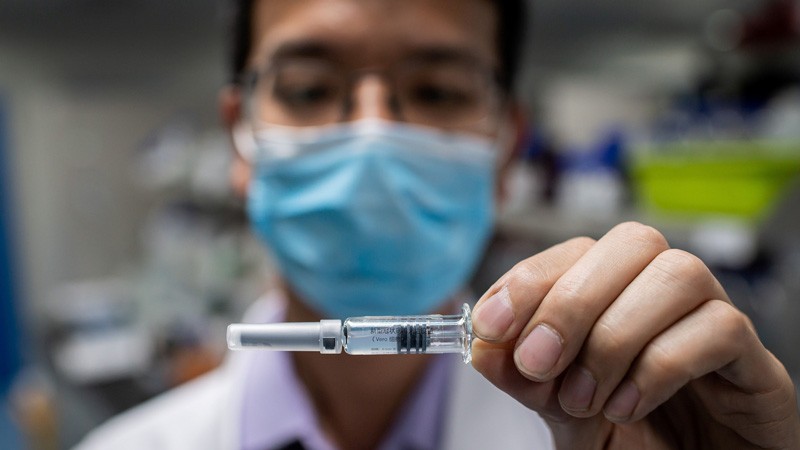 An engineer shows an experimental vaccine for the COVID-19 coronavirus.