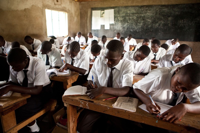 Students at a high school in Kenya work at desks in a classroom