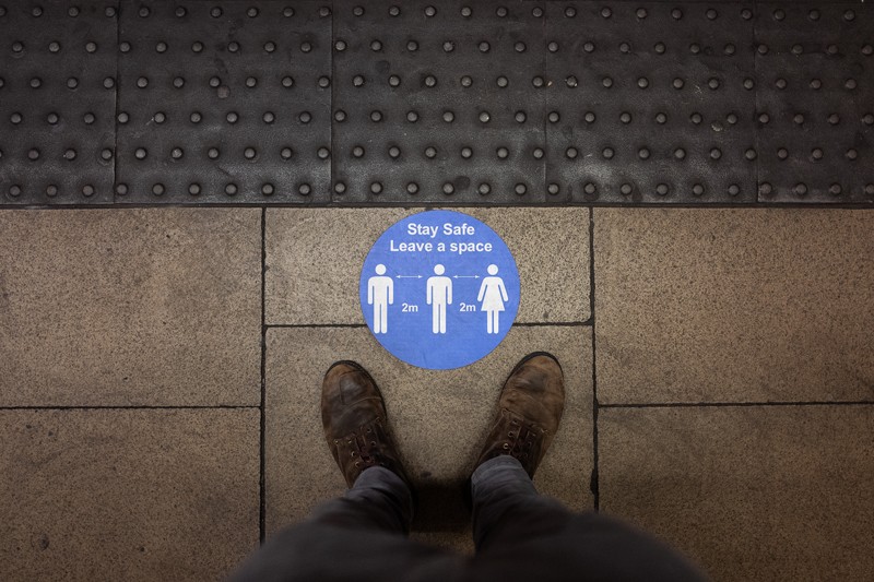 A social distancing sticker is seen on an underground station platform